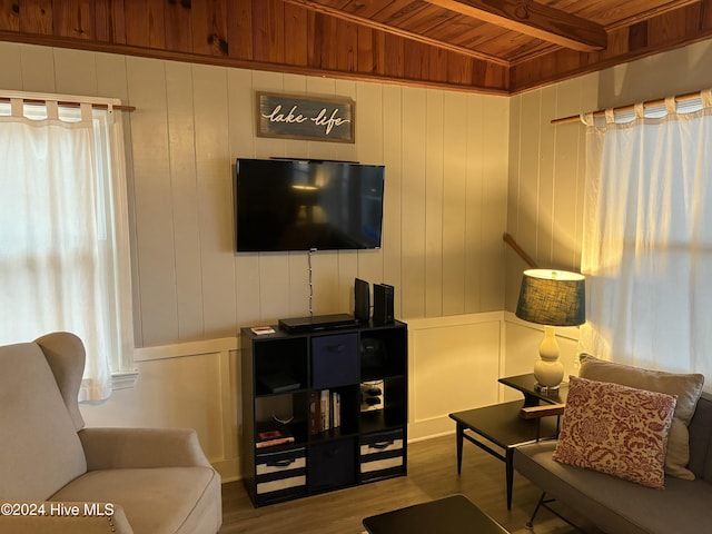 living room featuring vaulted ceiling with beams, light wood-type flooring, and wooden ceiling