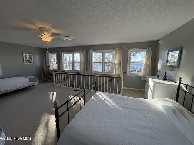 bedroom featuring carpet flooring, a textured ceiling, and ceiling fan