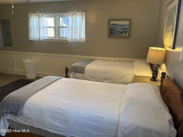 bedroom with electric panel and dark hardwood / wood-style floors