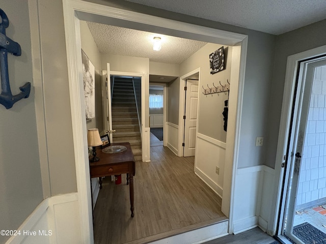 hallway with dark hardwood / wood-style floors and a textured ceiling