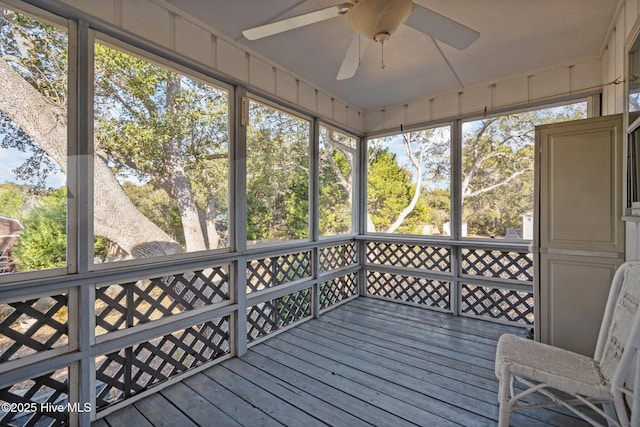 unfurnished sunroom featuring ceiling fan and a wealth of natural light