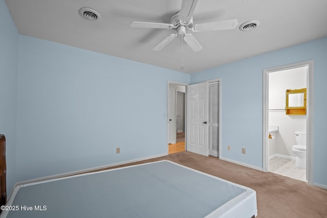 bedroom with light carpet, connected bathroom, visible vents, and baseboards