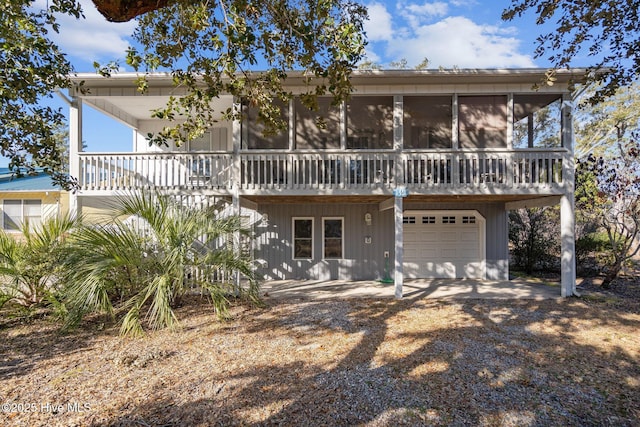 view of front of home with a garage, a sunroom, and driveway