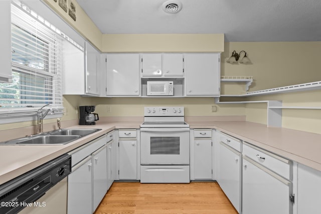 kitchen featuring white cabinets, white appliances, and light countertops