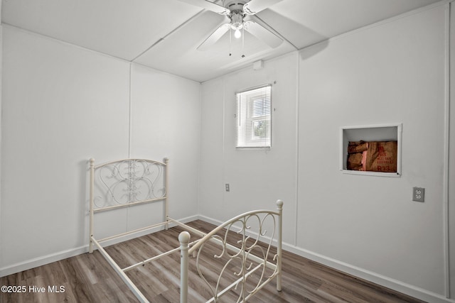 unfurnished room with ceiling fan, wood finished floors, and baseboards