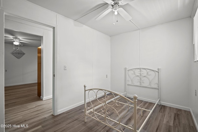 spare room featuring ceiling fan, baseboards, and wood finished floors