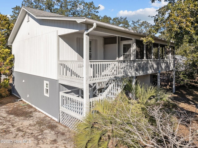 view of side of home featuring covered porch