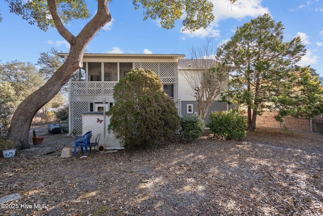 back of property featuring fence and a sunroom