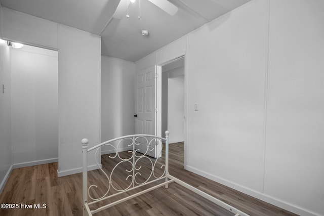 interior space featuring ceiling fan, baseboards, and dark wood finished floors