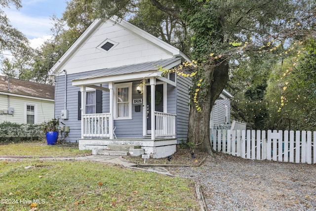 bungalow-style home featuring a front lawn and covered porch