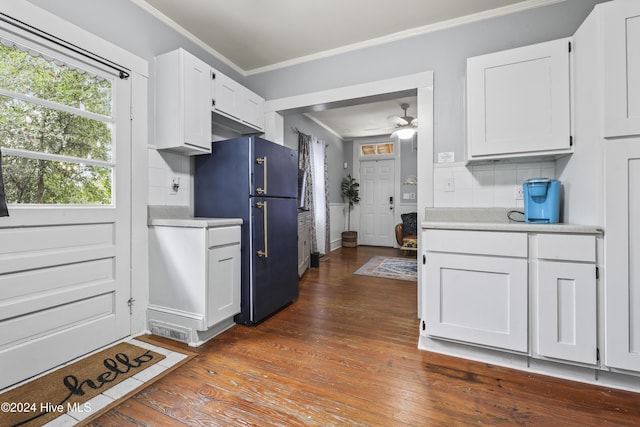 kitchen with backsplash, white cabinets, crown molding, fridge, and dark hardwood / wood-style flooring