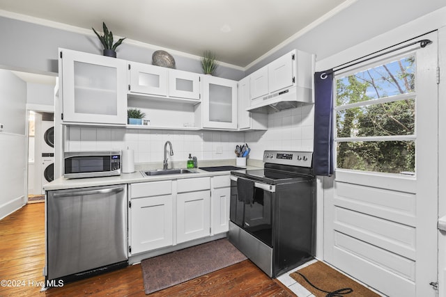 kitchen featuring white cabinets, sink, dark hardwood / wood-style flooring, stacked washer / dryer, and stainless steel appliances