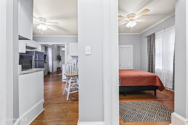 bedroom featuring dark hardwood / wood-style flooring, refrigerator, ceiling fan, and crown molding