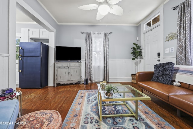 living room with dark hardwood / wood-style flooring, ceiling fan, and ornamental molding