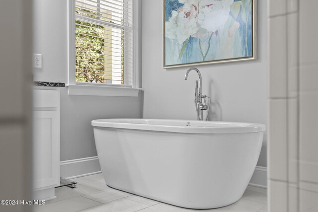 bathroom with tile patterned floors and a bath