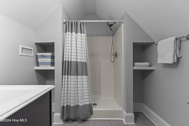 bathroom featuring tile patterned floors, a shower with curtain, vanity, and vaulted ceiling