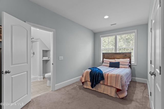 carpeted bedroom featuring ensuite bath