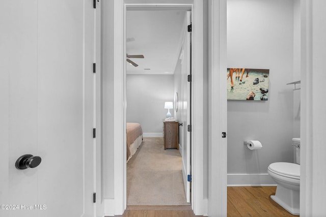 bathroom featuring hardwood / wood-style flooring, toilet, and ceiling fan