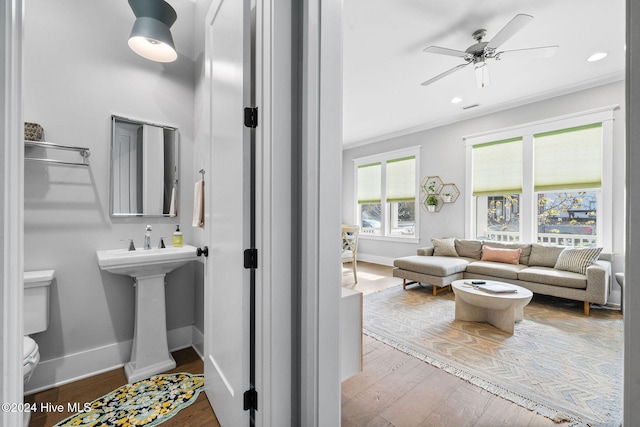 bathroom featuring hardwood / wood-style flooring, toilet, ceiling fan, and ornamental molding