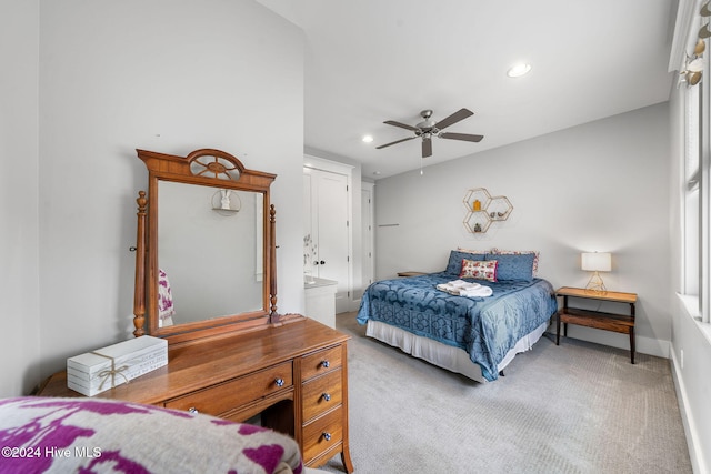 bedroom with connected bathroom, ceiling fan, and light carpet