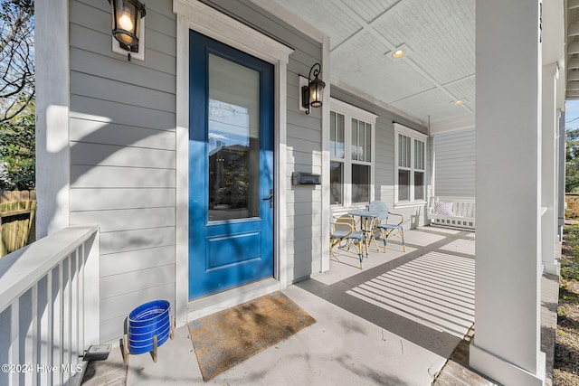 view of exterior entry featuring covered porch