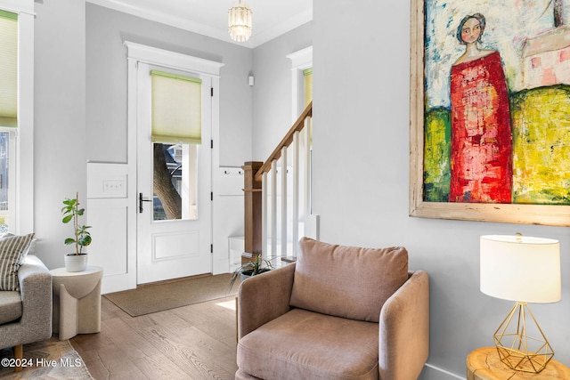 living area featuring wood-type flooring and ornamental molding