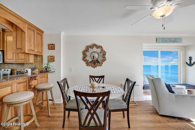 dining room featuring a water view, ceiling fan, and light hardwood / wood-style floors