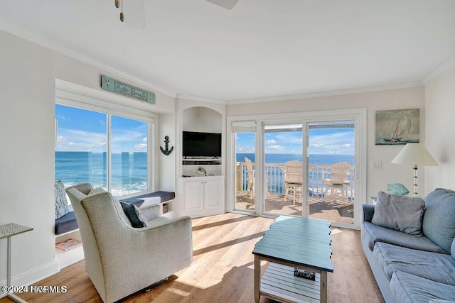 living room featuring plenty of natural light, light wood-type flooring, and crown molding