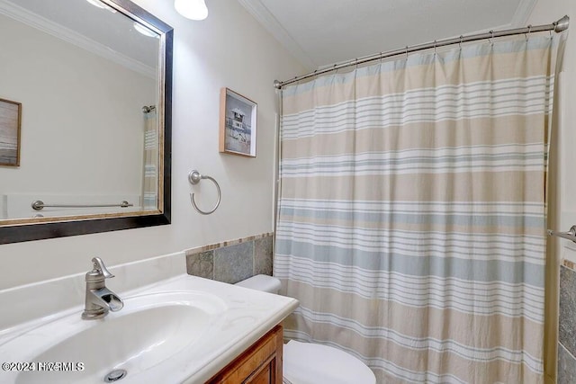 bathroom with a shower with curtain, vanity, toilet, and ornamental molding