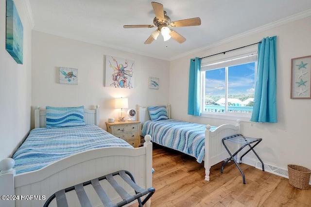 bedroom with ceiling fan, light hardwood / wood-style floors, and crown molding