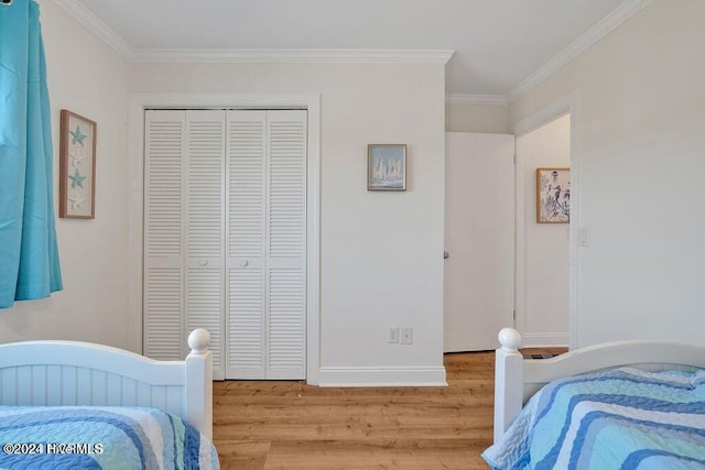 bedroom featuring a closet, light hardwood / wood-style floors, and ornamental molding