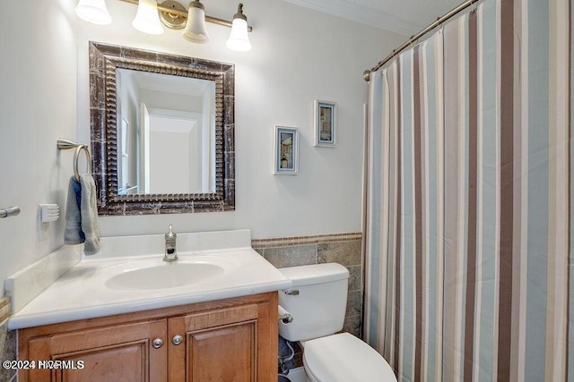 bathroom featuring vanity, curtained shower, toilet, and tile walls