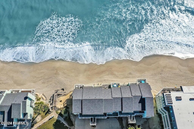 birds eye view of property featuring a water view and a beach view