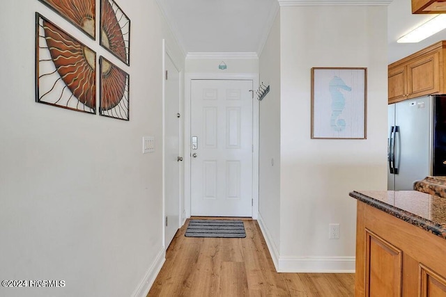 entryway with light wood-type flooring and crown molding