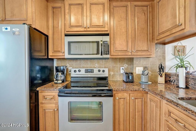 kitchen featuring light stone countertops, stainless steel appliances, and tasteful backsplash