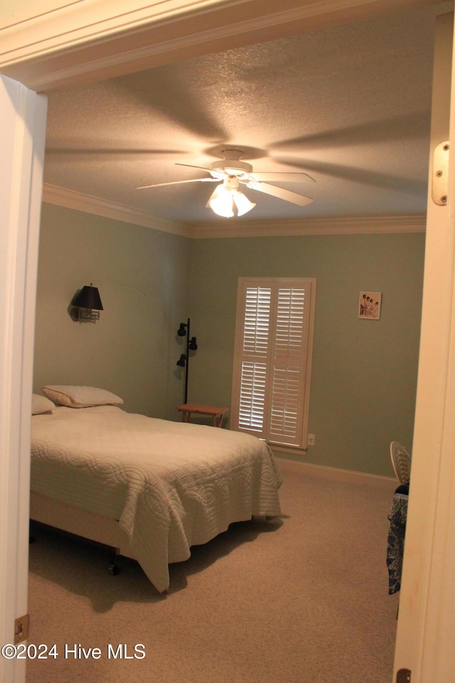 carpeted bedroom featuring ceiling fan and ornamental molding