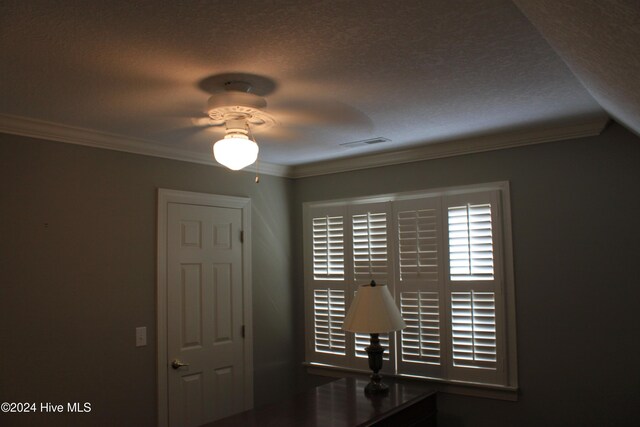 unfurnished office featuring crown molding and a textured ceiling