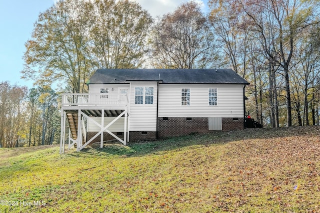 rear view of property with a deck and a lawn