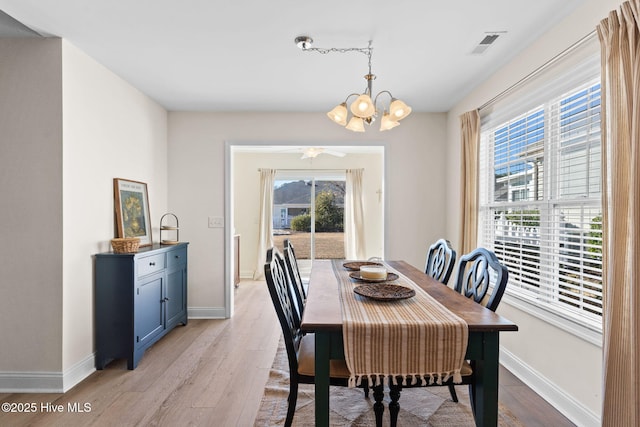 dining area with a notable chandelier, a healthy amount of sunlight, and light wood-type flooring