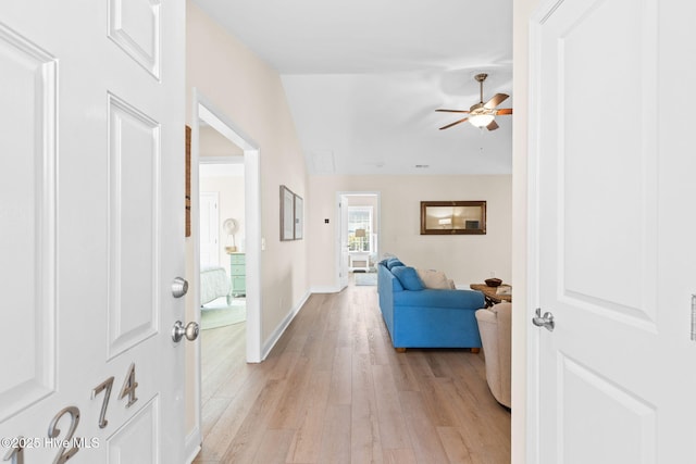 foyer entrance with ceiling fan, light hardwood / wood-style flooring, and lofted ceiling