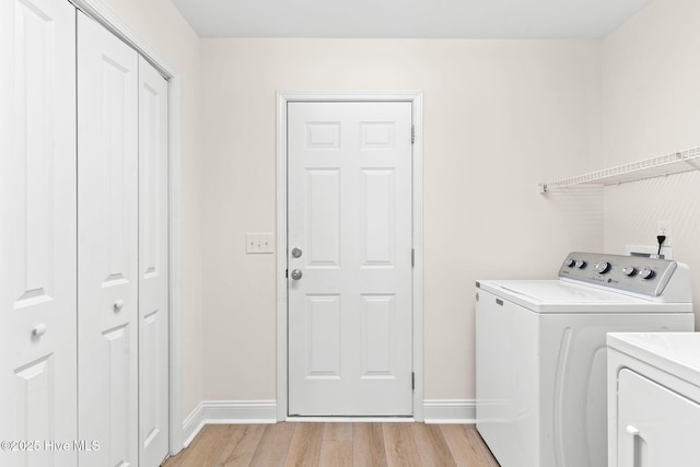 washroom with light hardwood / wood-style flooring and washing machine and dryer