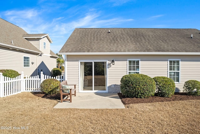 back of property with a lawn and a patio