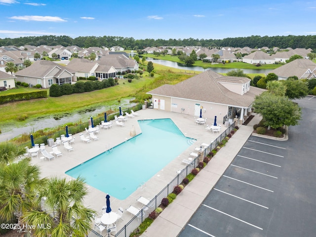 view of swimming pool featuring a patio and a water view