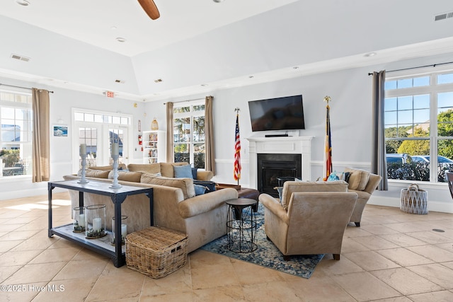 tiled living room featuring ceiling fan, a towering ceiling, and a healthy amount of sunlight