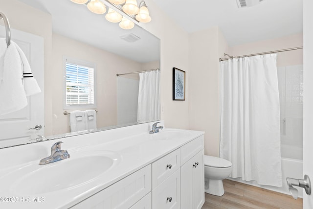 full bathroom featuring hardwood / wood-style floors, vanity, a notable chandelier, shower / bath combination with curtain, and toilet