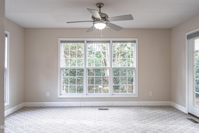 unfurnished room with ceiling fan, light colored carpet, and a textured ceiling