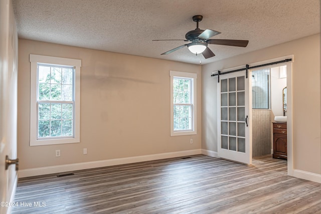 unfurnished room with ceiling fan, hardwood / wood-style floors, and a textured ceiling