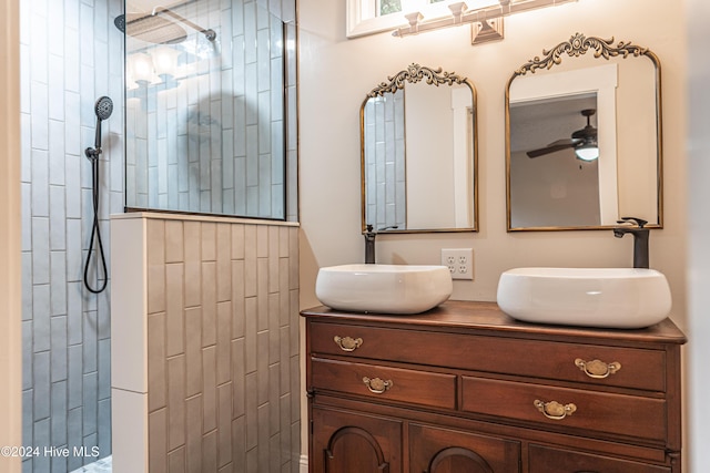 bathroom with ceiling fan, vanity, and tiled shower