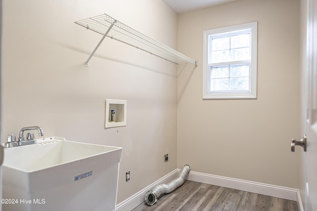 washroom with hookup for an electric dryer, wood-type flooring, sink, and hookup for a washing machine