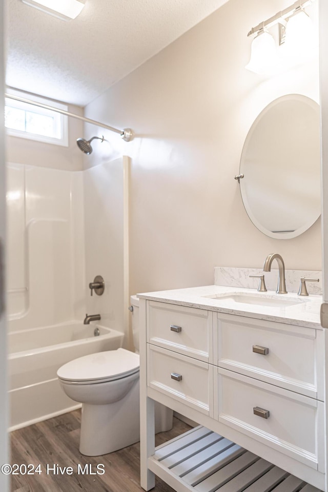 full bathroom featuring toilet, hardwood / wood-style floors, vanity, and bathing tub / shower combination